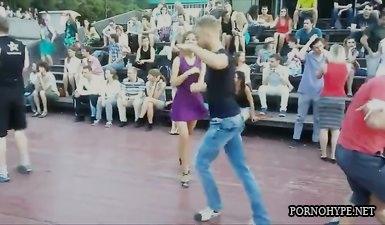 Російська дівчина в короткому платті світить апетитною попкою під час танцю на вулиці